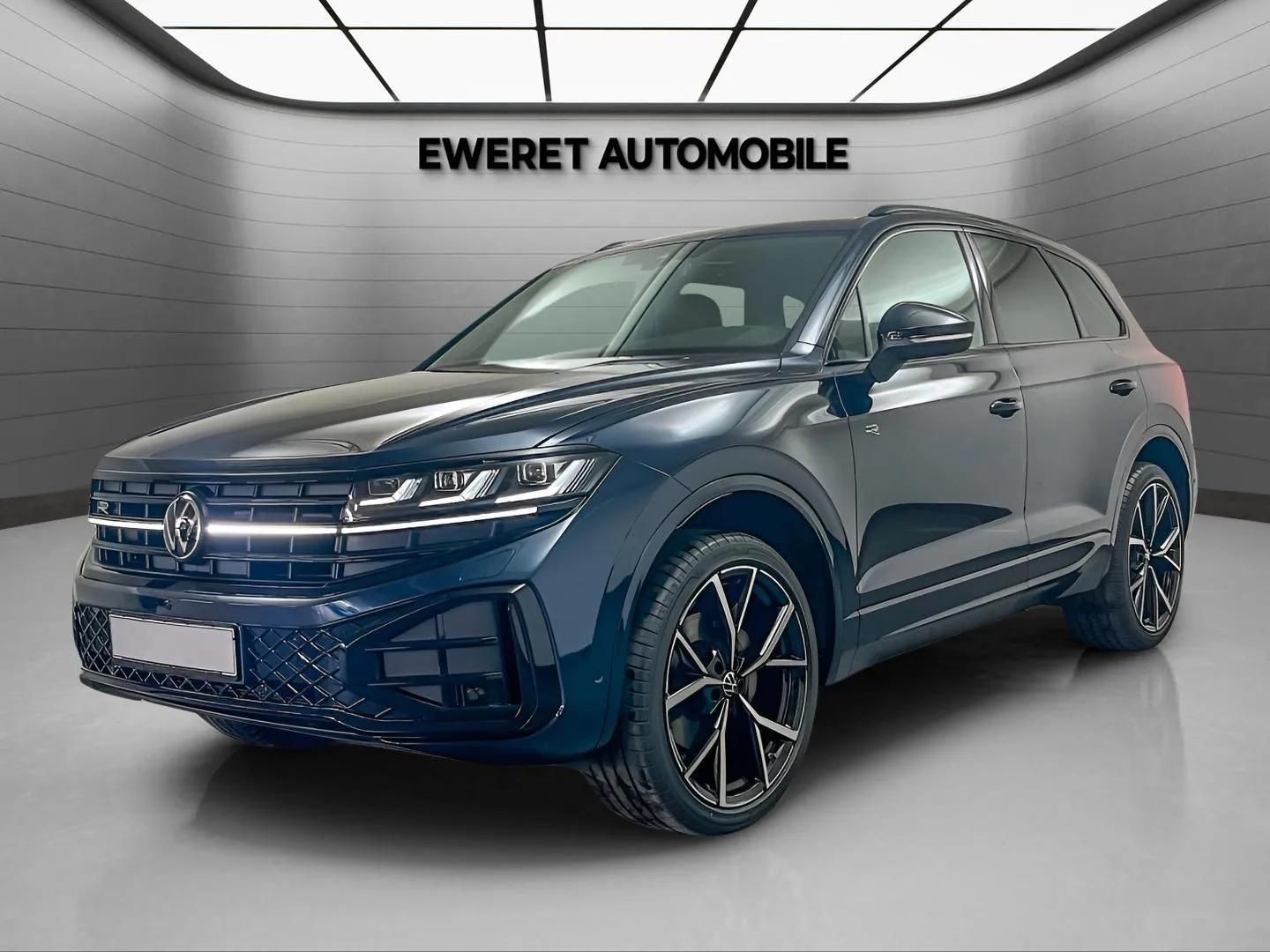 Sleek black SUV parked in a modern automotive showroom with geometric ceiling.